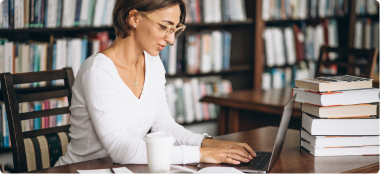 young woman sitting library using books computer